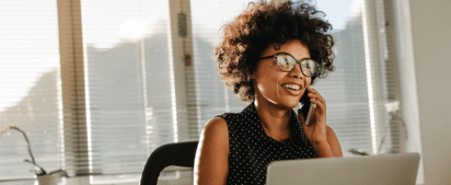 woman wearing glasses talking on the phone