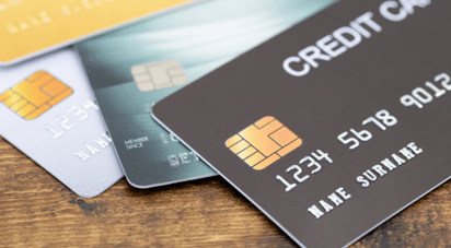 Three credit cards fanned out on a wooden table