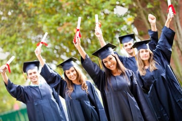 Happy group of students with arms up at their graduation