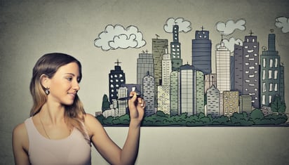 Woman drawing city skyline on grey wall background. Real estate development, house market economy, investment opportunity