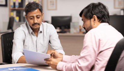 indian man talking to a banker discussing a document