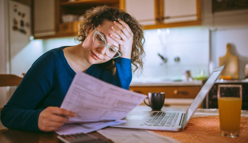 woman wearing glasses reading her bills