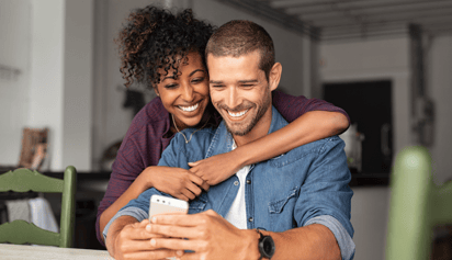 couple smiling and looking at a phone
