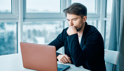 man working on his laptop and thinking