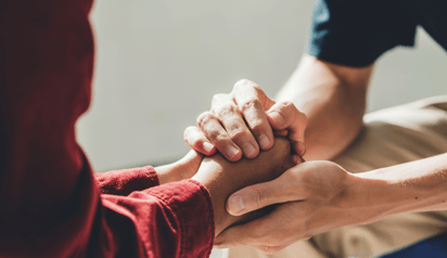 people holding hands and providing support