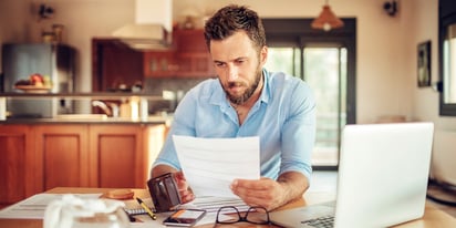man reviewing bank statement at home