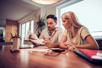 Couple going over bills and budget trying to figure out how to pay their credit card bill from last month's spending